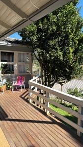 a wooden deck with a white fence and a tree at Casa em Gramado in Gramado