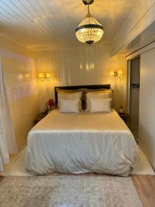 a bedroom with a large white bed with a chandelier at Casa em Gramado in Gramado