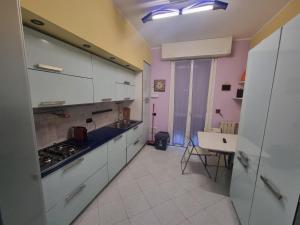 a kitchen with white cabinets and a stove top oven at Casa Via Asti in Piacenza