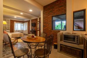 a living room with a table and chairs and a brick wall at Wayta Qinti in San Salvador de Jujuy