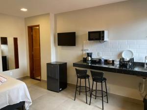 a kitchen with a counter and two bar stools at Morada do Sol Suítes in Arraial do Cabo