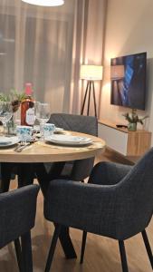 a table with glasses and a bottle of wine on it at Apartamenty Września IV in Września