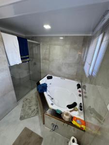 a bathroom with a bath tub and a shower at Casa em Gramado in Gramado +16 photos
