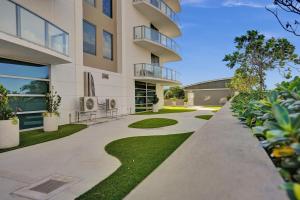an apartment building with a walkway and grass at 2BR Ocean Views Condo in West Palm in Riviera Beach