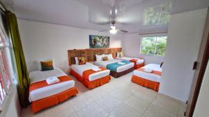 a room with three beds and a couch in it at Hotel Campestre Villa Esmeralda in Pereira