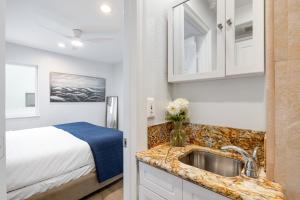 a kitchen with a sink and a bed in a room at Sandy by AvantStay Oceanview Steps to Beach Patio w Fire Pit Dining Area in Newport Beach
