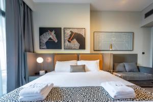 een slaapkamer met een groot bed en een bank bij Canal View Studio Downtown - Near Dubai Mall & Burj Khalifa - MAG 318 in Dubai +35 foto's