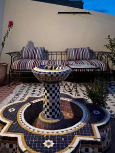 a fountain in the middle of a patio with a couch at Appartements 7 min Aéroport Marrakech Menara dar Nahila in Marrakesh