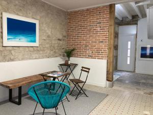a room with a table and chairs and a brick wall at A1 Spacieux appartement 2eme etage in Évaux-les-Bains