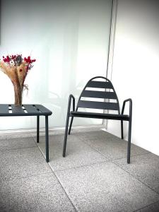 a chair and a table with a vase of flowers at Appartement Vannes Odyssée in Vannes