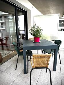 a blue table with chairs and a potted plant on it at Appartement Vannes Odyssée in Vannes