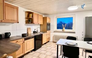 a kitchen with wooden cabinets and a table and a window at BEGE APARTMENTS WorkLodge in Duisburg