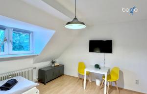 a living room with a table and yellow chairs at BEGE APARTMENTS WorkLodge in Duisburg +7 photos