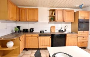 a kitchen with wooden cabinets and a black dishwasher at BEGE APARTMENTS WorkLodge in Duisburg