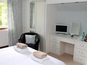 Schlafzimmer mit einem Bett und einem Schreibtisch mit einem Computer in der Unterkunft Westacre Bed & Breakfast in Crieff