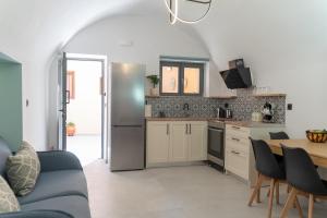 Una cocina con refrigerador de acero inoxidable y una mesa. en ARCH HOME, luxury property with private parking, en La Canea