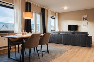 a dining room with a table and a couch at Design-FeWo Sonnendeck in Winterberg