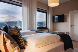 a bedroom with a large bed with a large window at Design-FeWo Sonnendeck in Winterberg