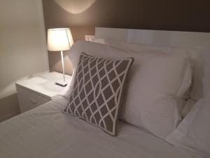 フィレンツェにあるカサ マロンの白いベッド(枕付)、ナイトスタンド(ランプ付)