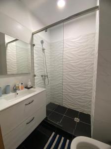 a bathroom with a shower and a sink and a toilet at Appartement Vue Mer piscine olympique in Aourir