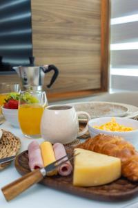a plate of cheese and bread and a cup of orange juice at Conforto e Estilo - 2 min da Praia in Porto De Galinhas +13 photos