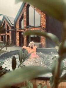 una mujer en un jacuzzi en una casa en Widać Wydmy, en Łeba