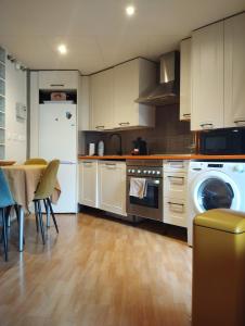 a kitchen with white cabinets and a washer and dryer at Fridda House Atocha Madrid in Madrid +19 photos