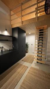a room with a loft with a staircase and a kitchen at Czarna Perła in Filipówka