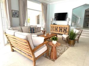 a living room with a couch and a tv at Silver Sands Beach Villas are great for family-friendly activities surfing in Christ Church