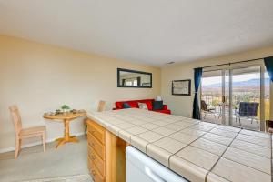 a room with a bed and a living room with a table at Las Palmas Condo with Pool Access in St George! in St. George