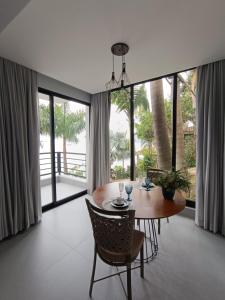 Un comedor con mesa y sillas y ventanas. en Lounge Suites De Luxo Piuva, en Ilhabela