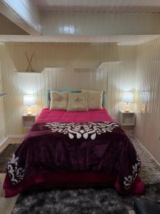 a bedroom with a large purple bed with two lamps at Casa em Gramado in Gramado