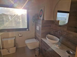 a bathroom with a sink and a toilet and a window at Villa Seaview in Nadole