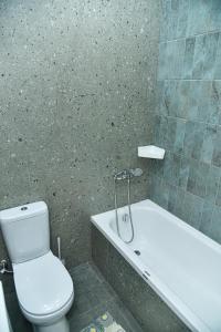 a bathroom with a white toilet and a bath tub at ЖК Бавария возле клиники Дару in Aktobe +7 photos