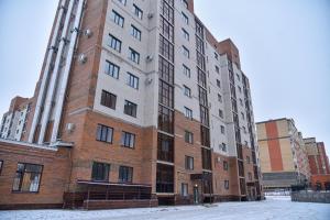 a tall brick building with snow in front of it at ЖК Бавария возле клиники Дару in Aktobe