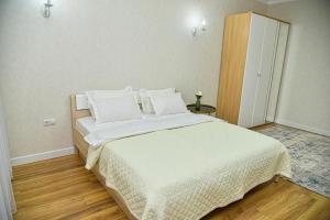 a bedroom with a large bed with white sheets and pillows at ЖК Бавария возле клиники Дару in Aktobe