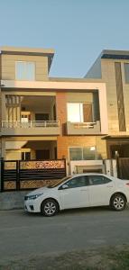 ein weißes Auto, das vor einem Haus parkt in der Unterkunft Hotel in Islamabad Luxurious 2 Bedroom in Islamabad