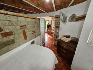 a bedroom with a bed and a brick wall at Las Cabañas del Tio Lalo in Rincon de Guayabitos +69 photos