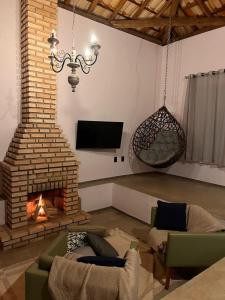 a living room with a couch and a fireplace at Casa Descanso Acuruí in Itabirito
