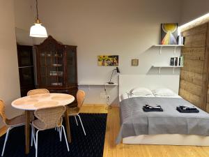Un dormitorio con una cama y una mesa y sillas. en Sisters Beach Apartments, en Liepāja