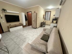 a living room with a couch and a flat screen tv at Nocciolino Home in Suzzara