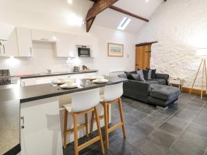 eine Küche und ein Wohnzimmer mit Tisch und Stühlen in der Unterkunft Cornel Glyd in Dyffryn