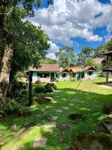 a house in a field with a grass yard at Pousada Brilho da Natureza in Visconde De Maua