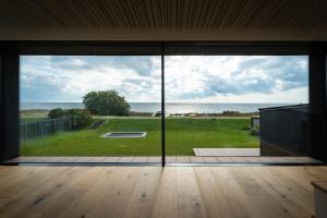 uma porta de vidro aberta com vista para o oceano em Ocean view in first row. Architectural pearl em Dragør