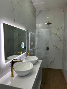 a bathroom with two sinks and a large mirror at H et L in Tortuguero +25 photos