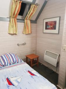 a bedroom with a bed and a radiator and a table at Ferienhaus 52 in Kirchheim