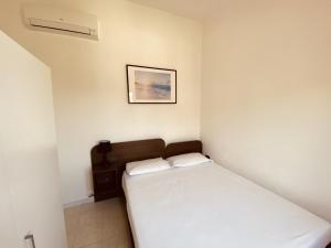 a small bedroom with a bed and a picture on the wall at Marasusa Apartments Scirocco 226CW in Parghelia +45 photos