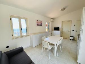 a living room with a white table and chairs at Marasusa Apartments Scirocco 226CW in Parghelia
