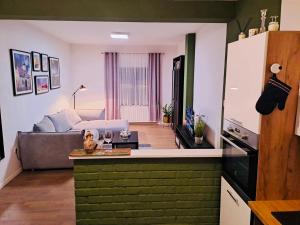 a kitchen and a living room with a couch at Apartman La vida in Zagreb
