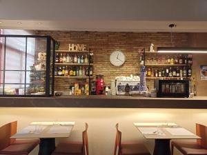 a restaurant with two tables and a clock on the wall at Hotel Villa de Zaragoza in Casetas